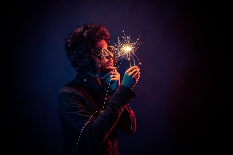 Free Image of Person holding sparkler with vibrant backdrop 
