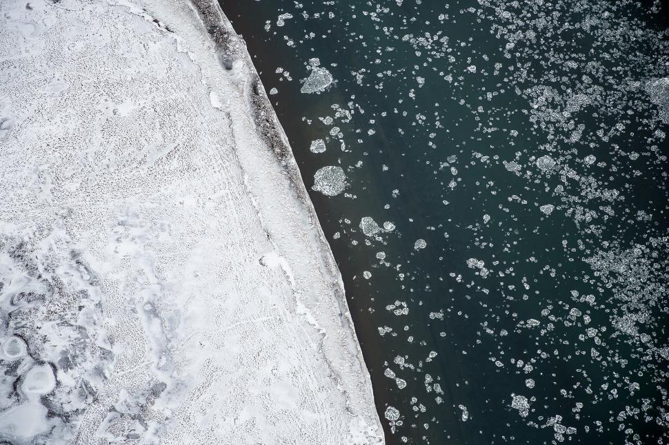 Free Image of Aerial view of icy river and snow-covered land 