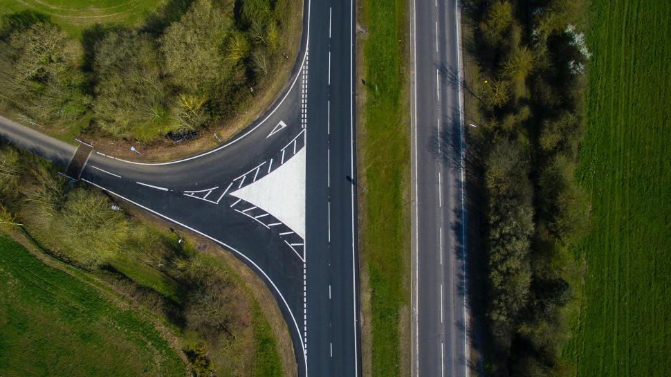 Free Image of Aerial view of a road splitting green fields 