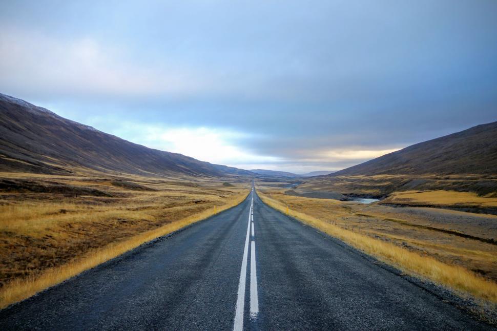Free Image of Desolate road amidst golden mountainous terrain 