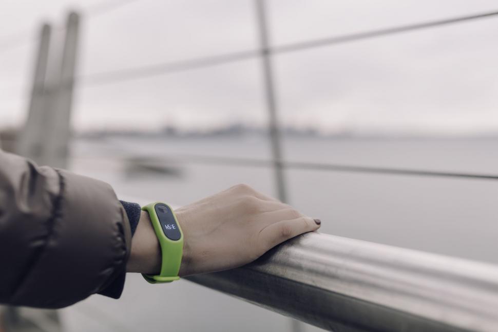 Free Image of Sports watch on a hand above railing 