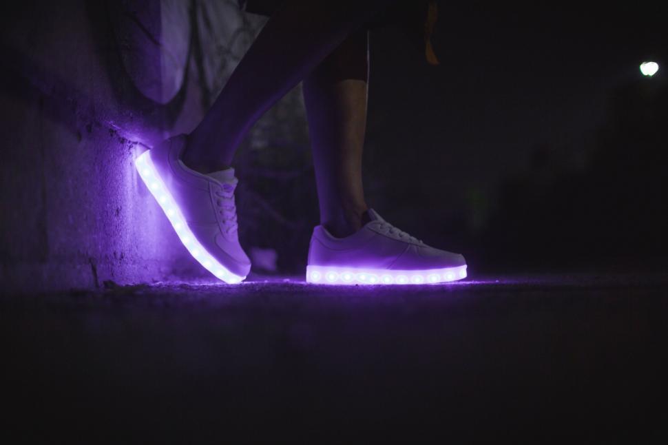 Free Image of Glowing sneakers on pavement at night 