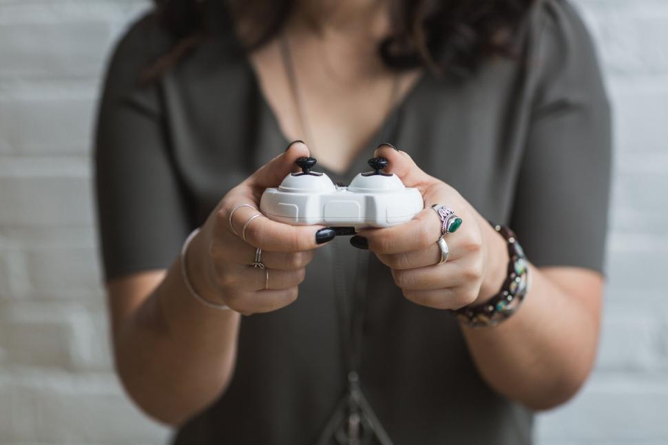 Free Image of Woman holding a game controller close up 