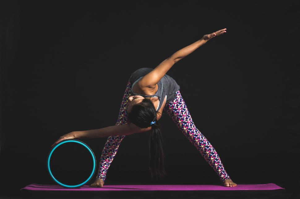 Free Image of Focused Woman Practicing Yoga with a Wheel Prop 