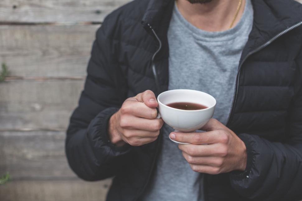 Free Image of Man holding a coffee cup wearing a jacket 