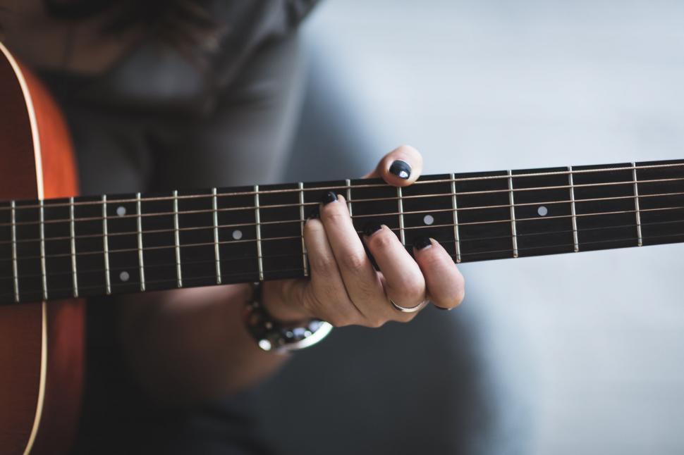 Free Image of Close-up of hands playing an acoustic guitar 