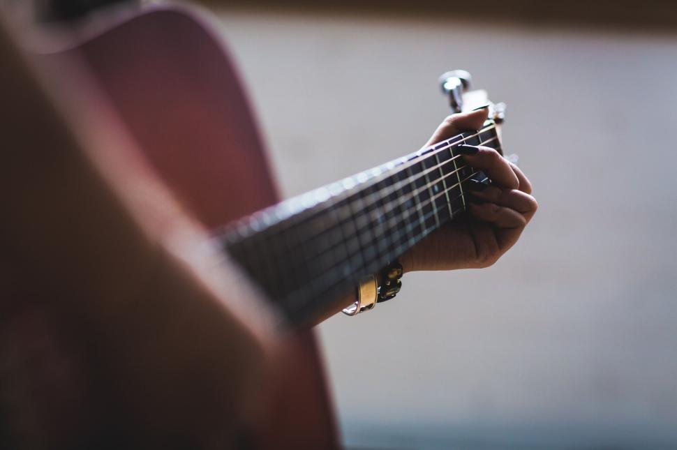 Free Image of Person s hands playing chords on a ukulele 
