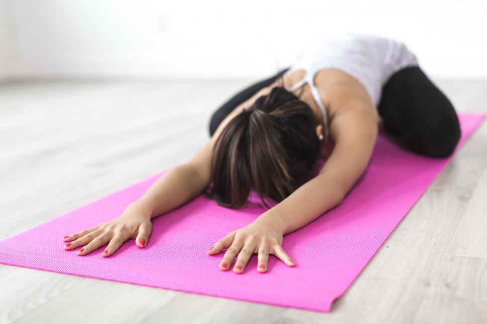 Free Image of Woman practicing yoga on a pink mat 