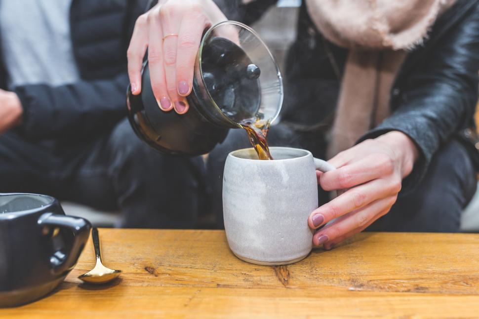 Free Image of Pouring coffee into a handmade ceramic cup 