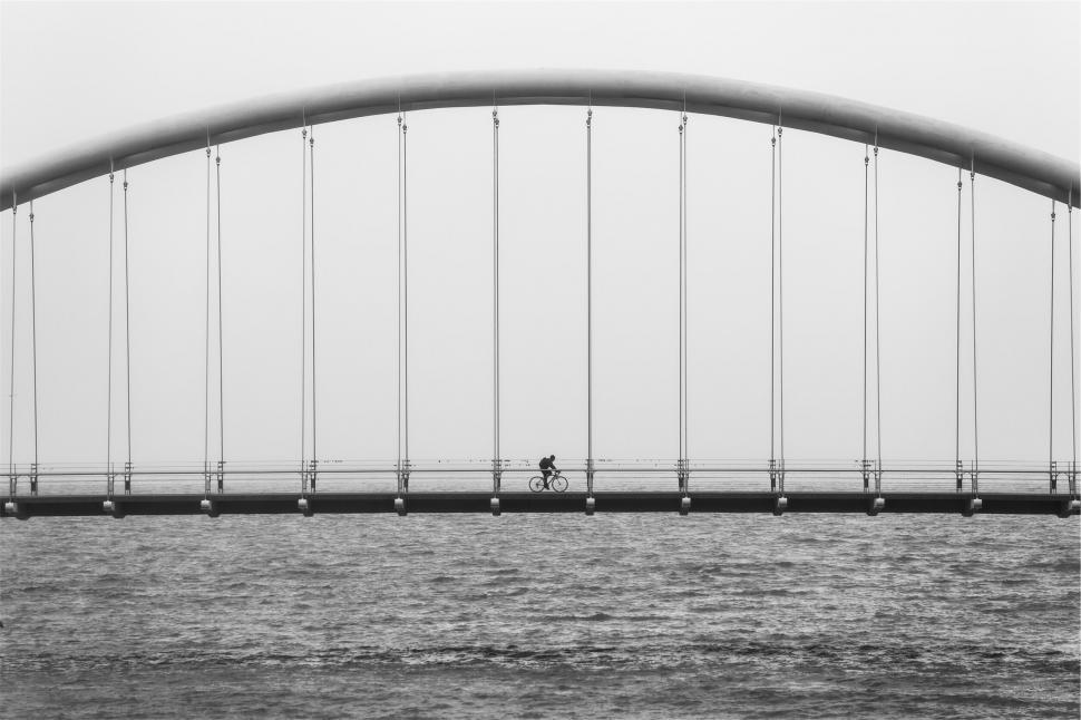 Free Image of Silhouette of cyclist on foggy bridge 