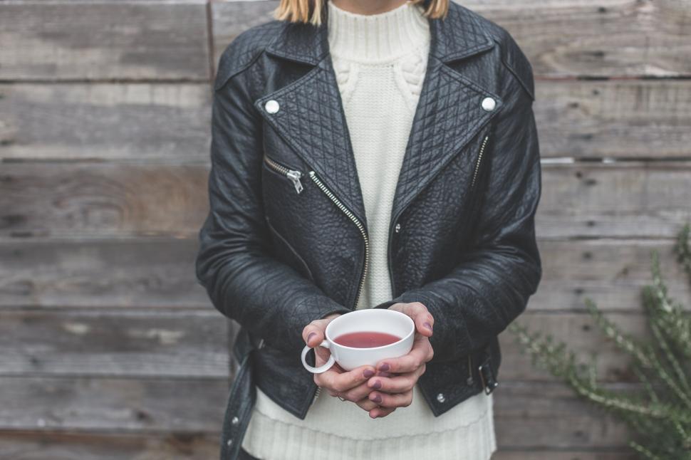 Free Image of Woman in leather jacket holding cup 