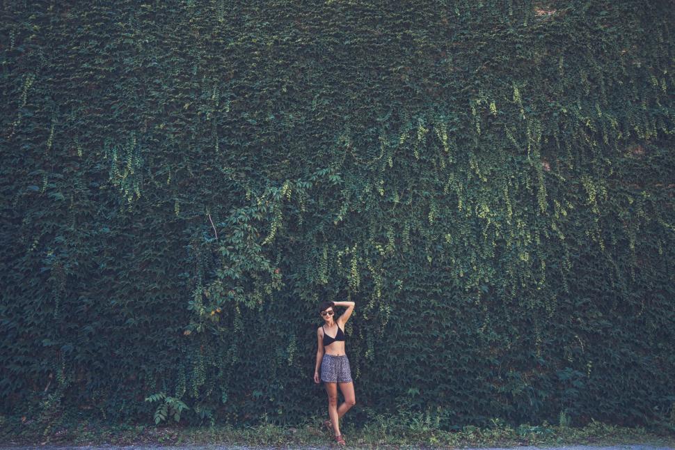 Free Image of Person standing under lush greenery wall 