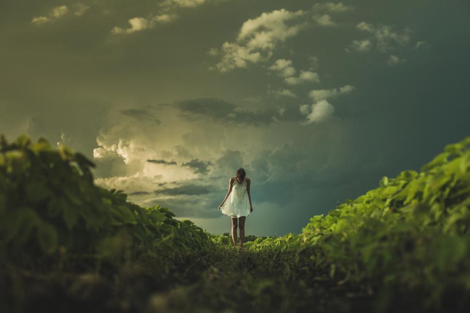 Free Image of Girl in white dress against stormy sky 