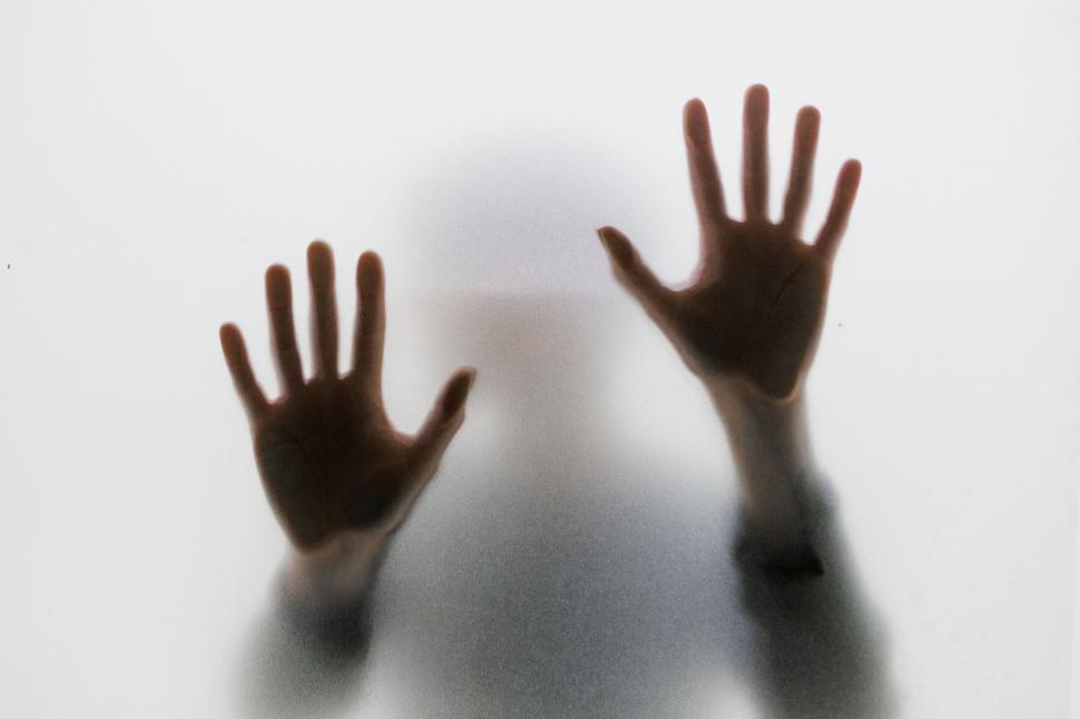 Free Image of Hands pressing against frosted glass 