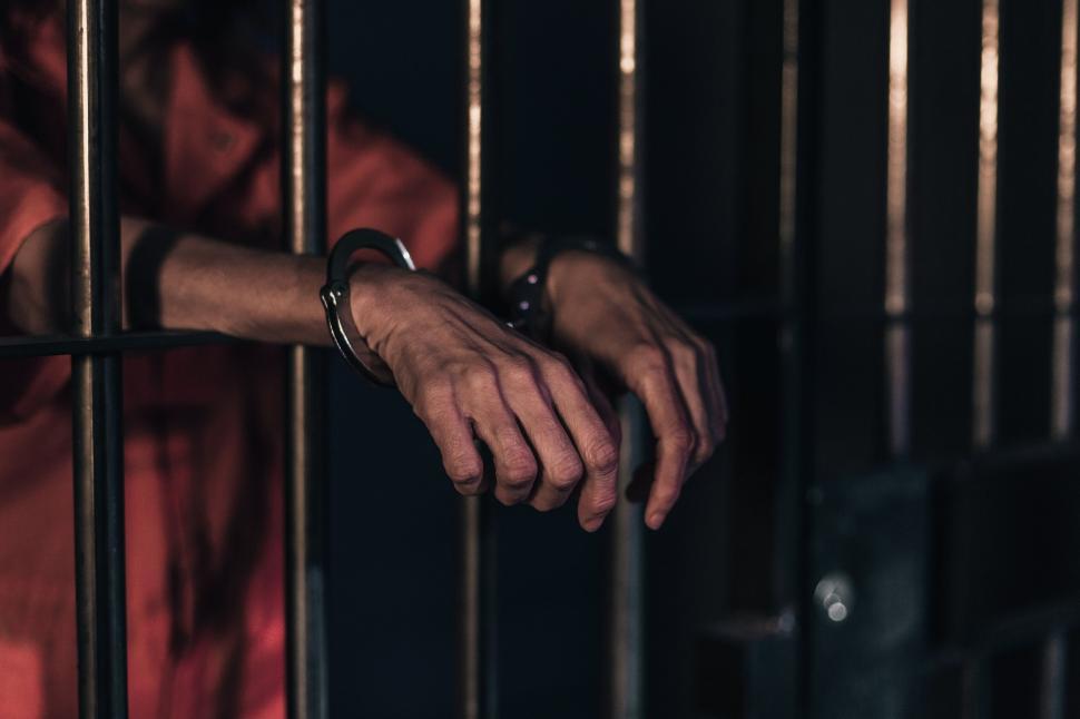 Free Image of Hands cuffed behind prison bars 