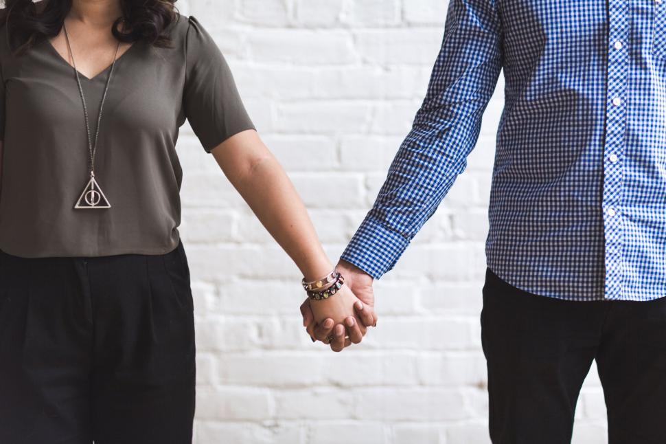 Free Image of Couple holding hands, focus on hands 