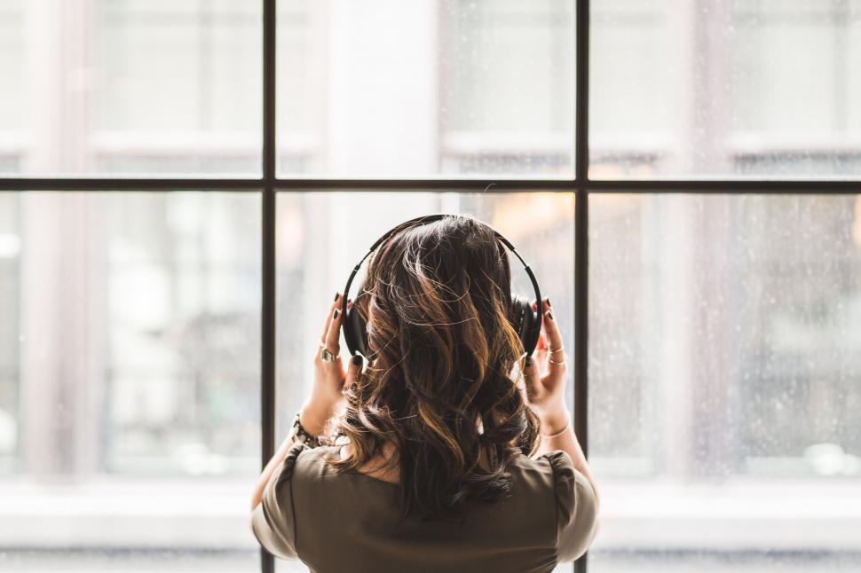 Free Image of Woman with headphones against window 