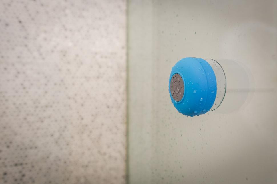 Free Image of Blue shower timer attached to wet glass 