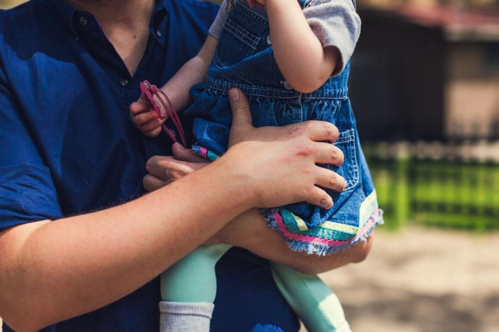 Free Image of Toddler being held by a parent in casual wear 