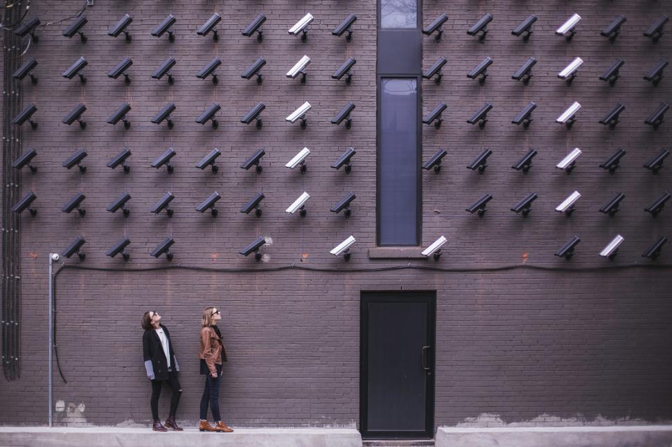 Free Image of Two people under surveillance camera wall 