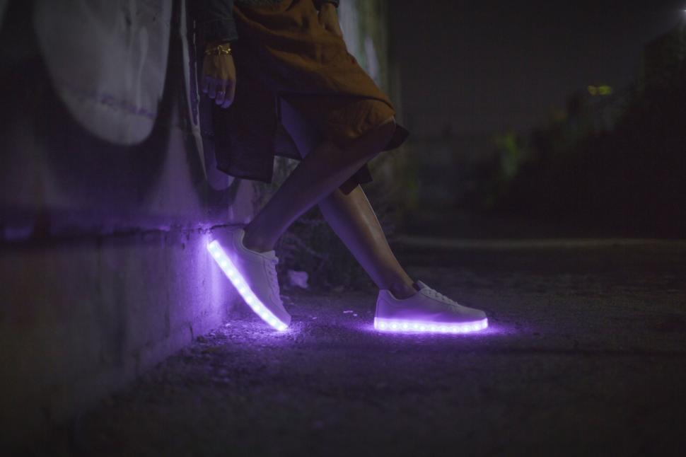 Free Image of Neon glow on sneakers in a nocturnal setting 