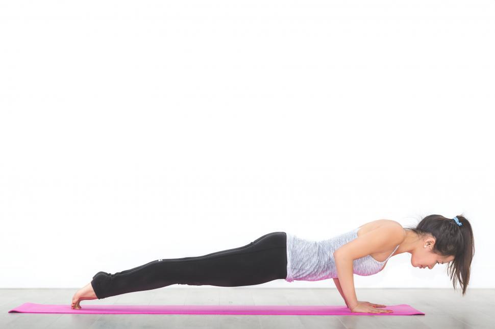 Free Image of Woman doing a plank exercise on a yoga mat 