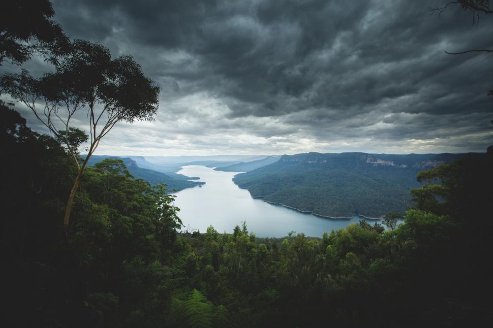 Free Image of Overcast sky above a serene river valley 