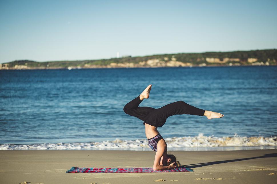 Free Image of Yoga practice on a sandy beach near ocean 
