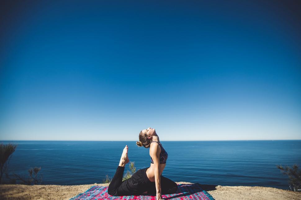 Free Image of Yoga pose against ocean backdrop on cliff 