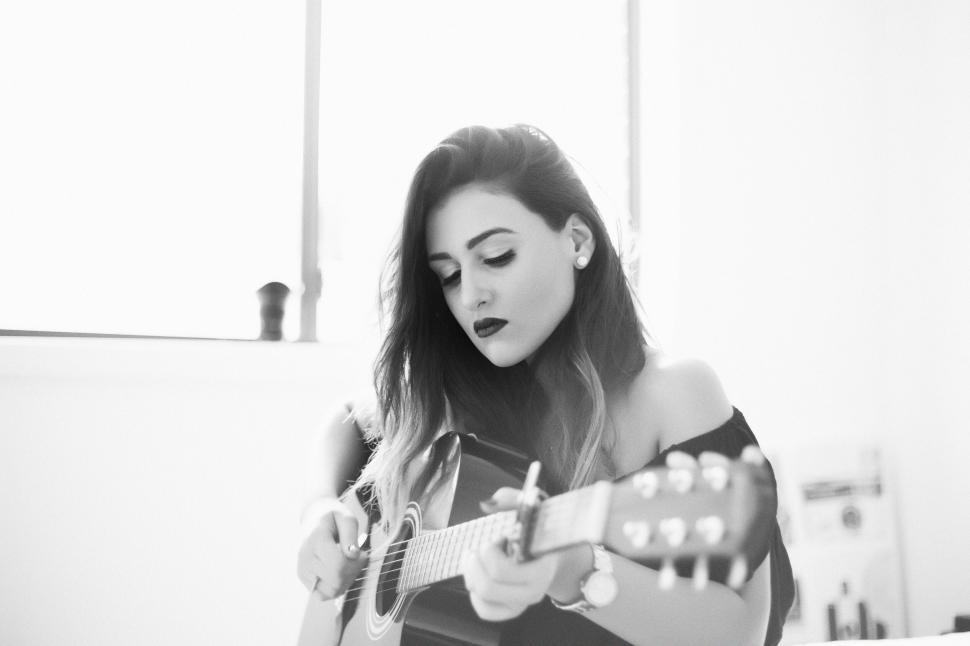Free Image of Woman playing guitar in black and white 