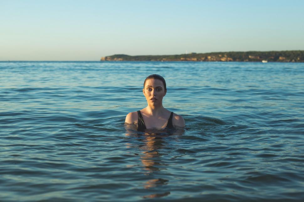Free Image of Woman submerged in water during sunset 