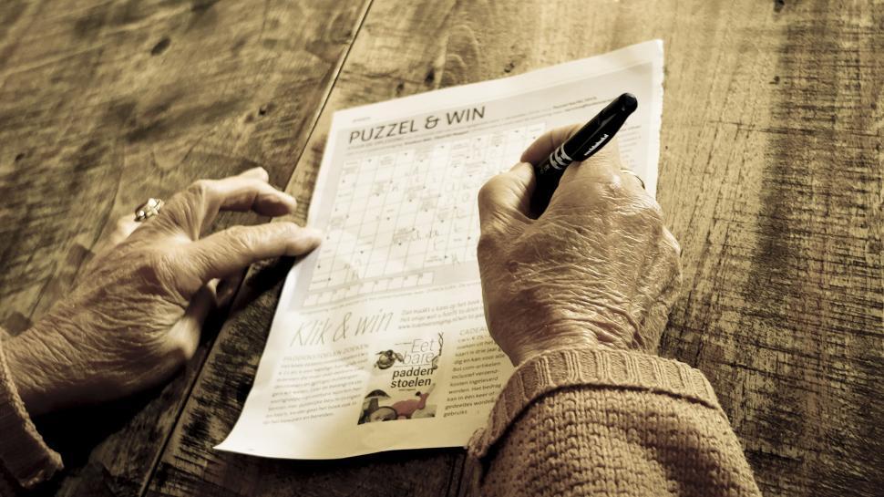 Free Image of Elderly person engaging in crossword puzzle 