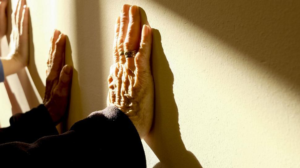 Free Image of Hands pressed against sunlit wall in warmth 