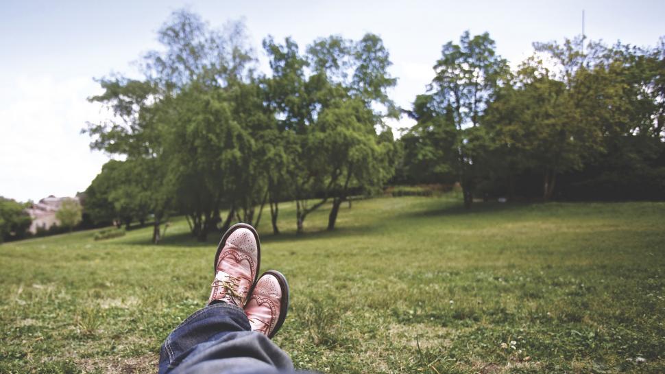 Free Image of Person relaxing in pink shoes on green grass 