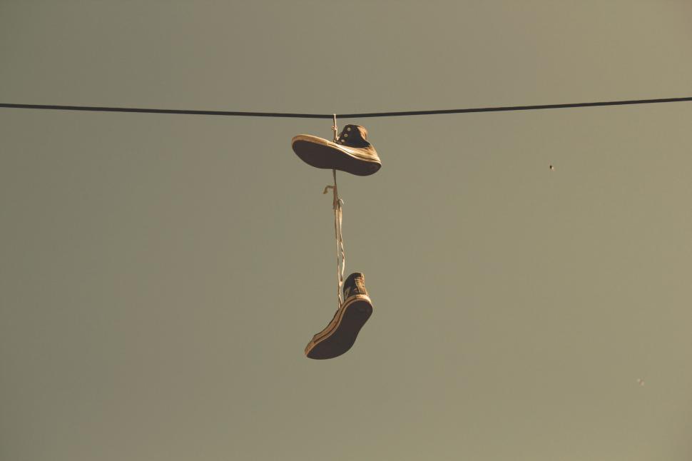 Free Image of Sneakers hanging from a wire in warm tones 