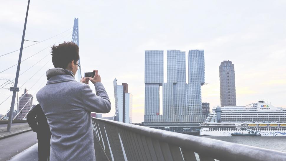 Free Image of Man photographing modern city skyscrapers 