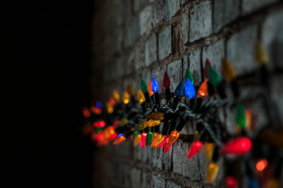 Free Image of Christmas lights on a rustic brick wall 