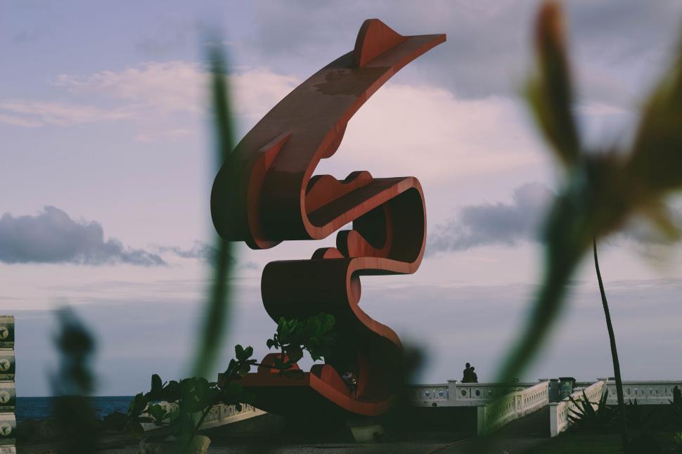 Free Image of Abstract red sculpture among tropical plants 