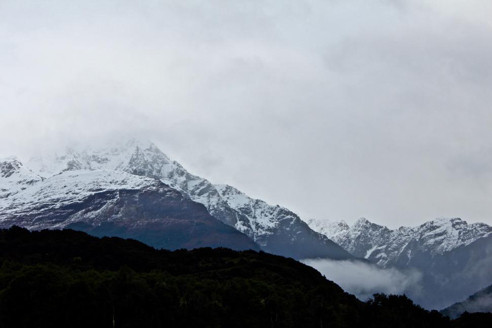 Free Image of Forested mountain peaks shrouded by clouds 