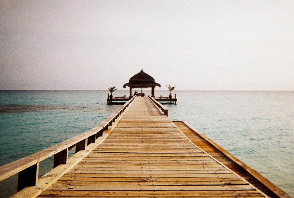 Free Image of Wooden Pier Leading to Ocean Hut at Dusk 