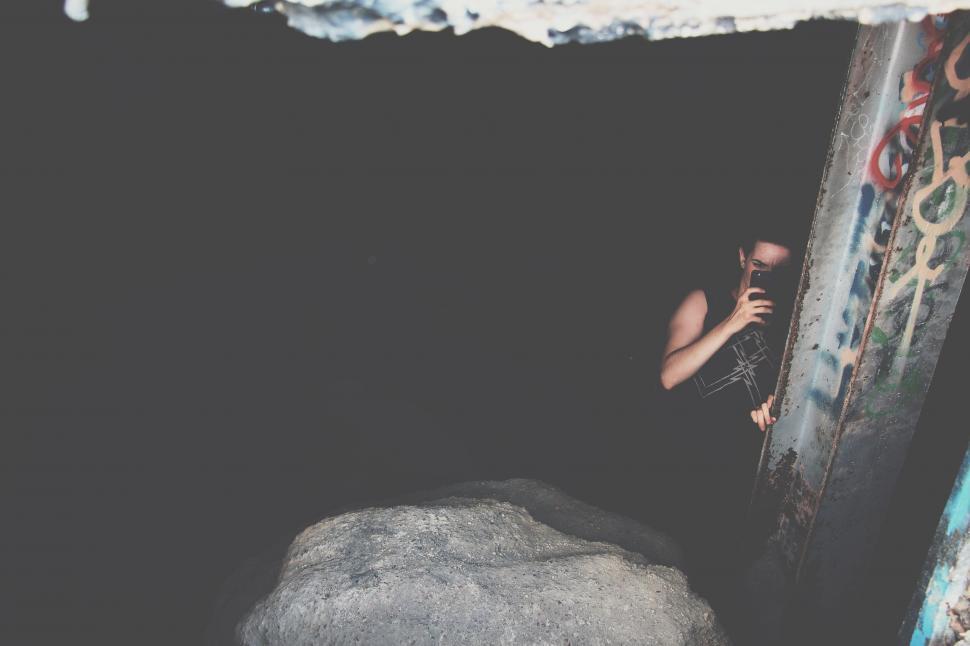 Free Image of Mysterious Person Peeking from Dark Cave 