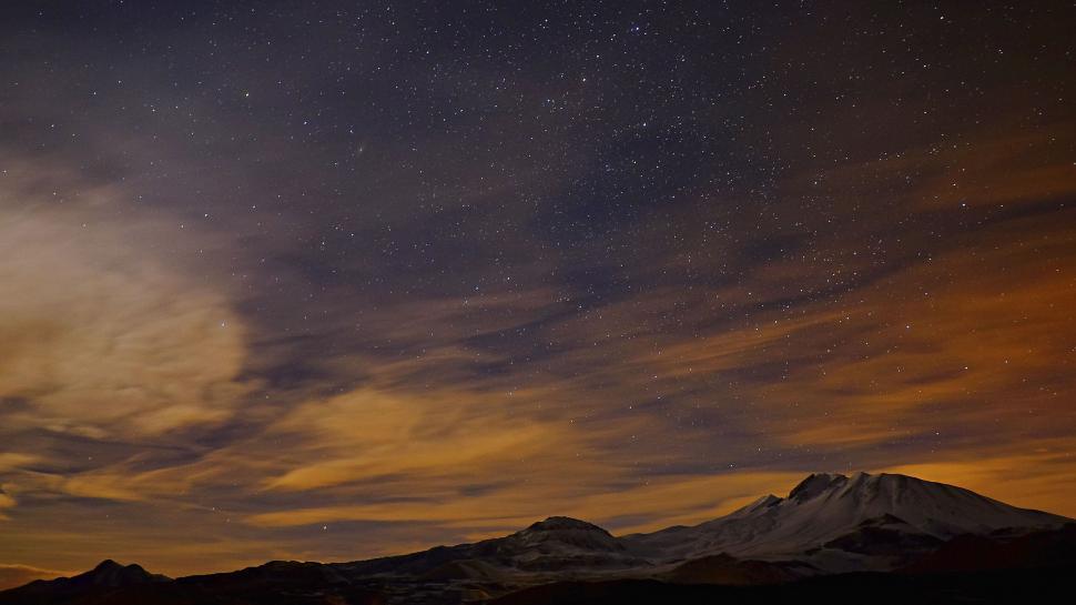 Free Image of Mountains under a starry sky with clouds 