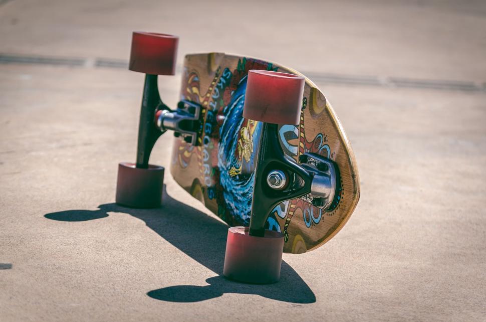 Free Image of Upside-down skateboard on sunny pavement 