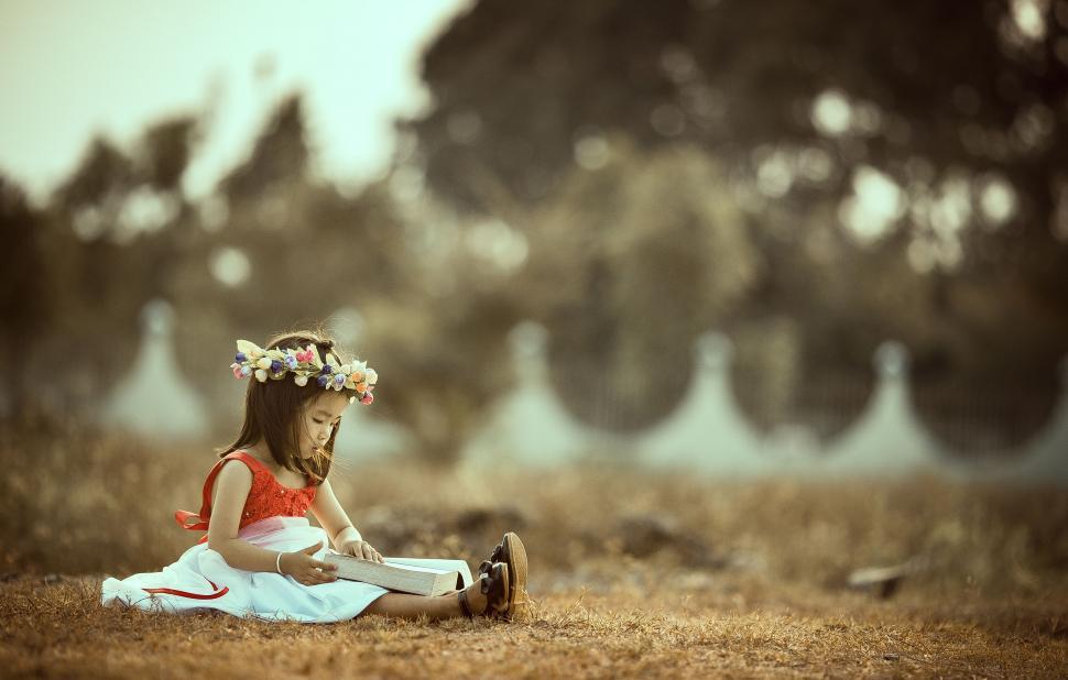 Free Image of Little girl reading in a natural setting 