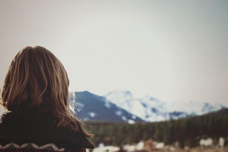 Free Image of Woman gazing at snowy mountains in distance 