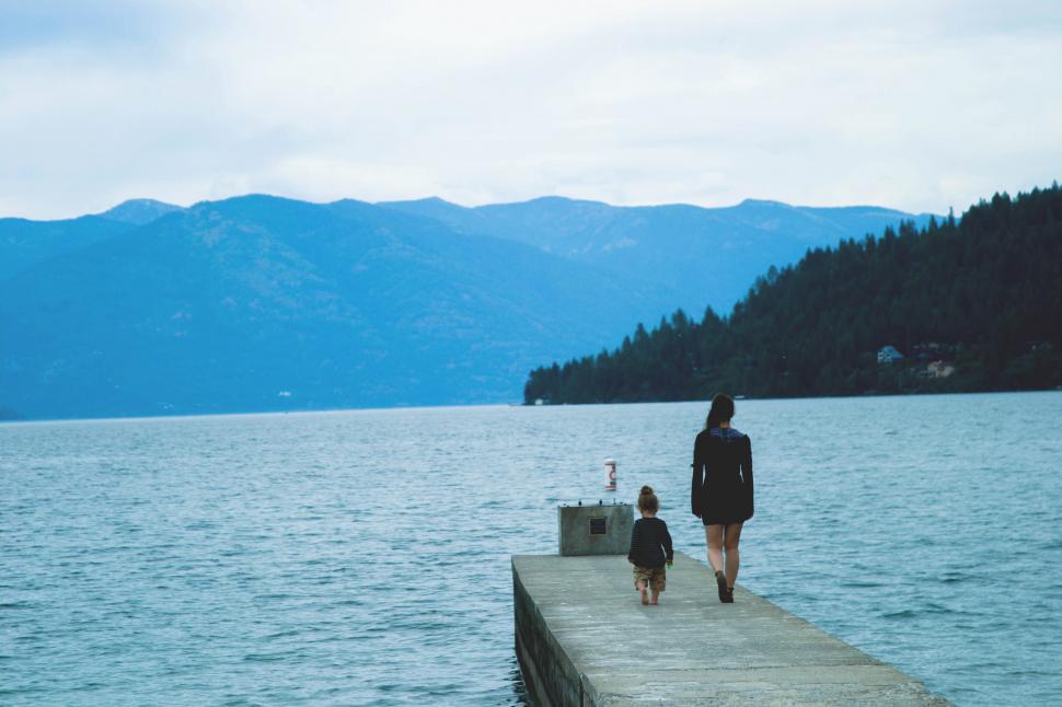 Free Image of Mother and child walking on a pier 