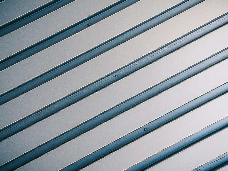 Free Image of Diagonal lines on a blue metal surface 