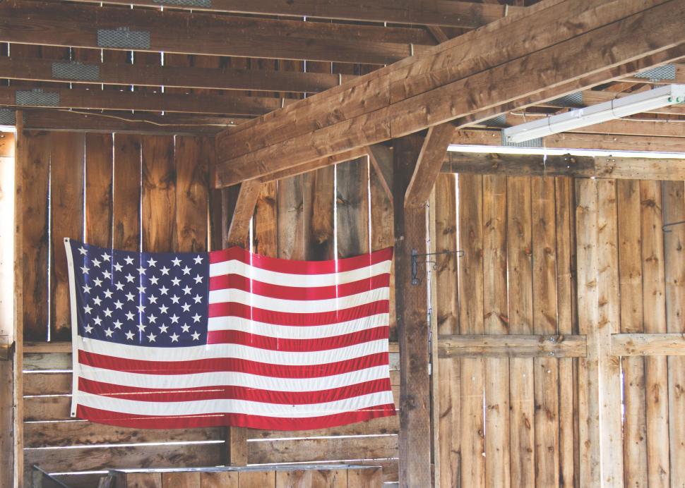 Free Image of American flag hung on a wooden barn wall 
