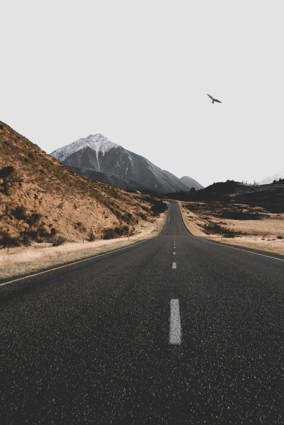Free Image of Empty road with mountain under cloudy skies 
