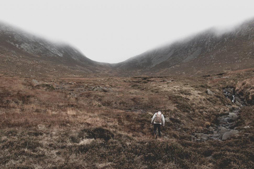 Free Image of Solitary person walking in a foggy valley 